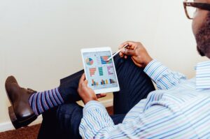 Man holding a tablet with a data dashboard on it